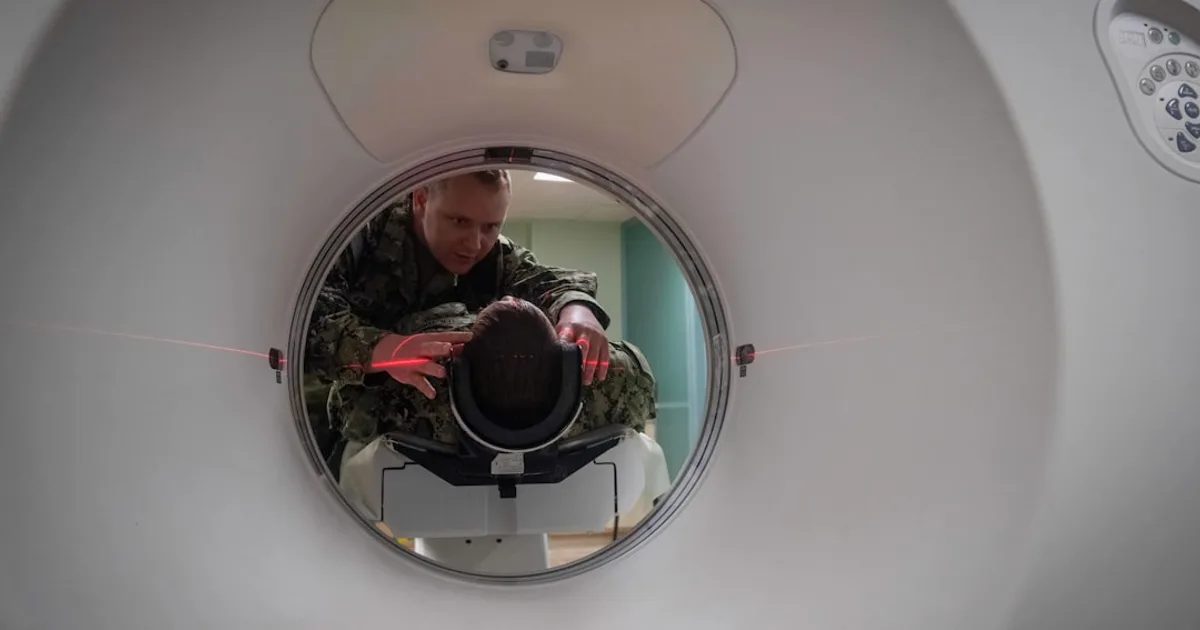 Technicien positionnant un patient dans un scanner CT en service de radiologie