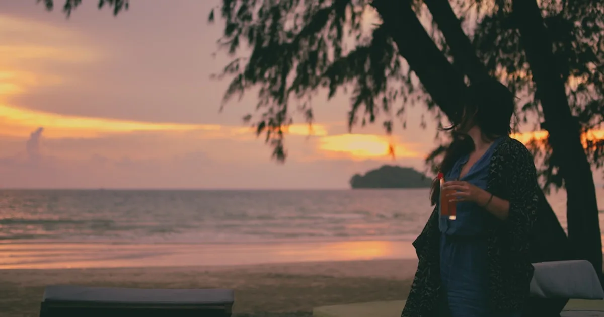 woman in blue dress standing on beach during sunset — illustration pour l'article sur fibrine riche en plaquettes PRF cicatrisation plaies chroniq