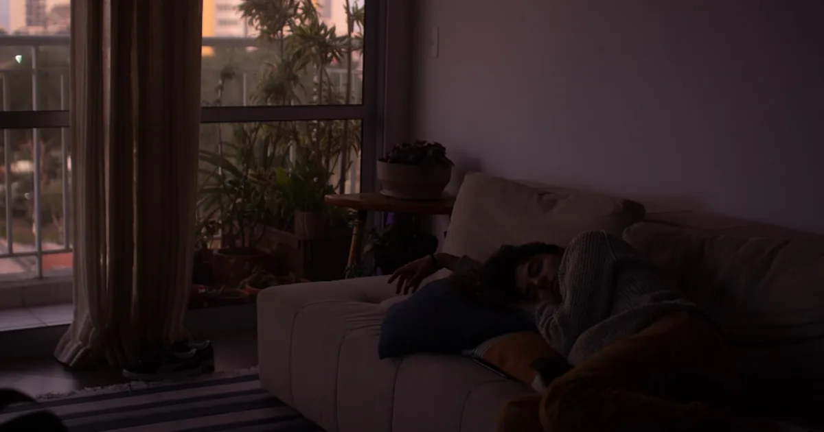 a person laying on a couch in front of a window — illustration pour l'article sur Insuffisance veineuse chronique   stades et evolution